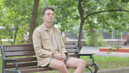 Obraz premium Modern Young Man Sitting on Bench