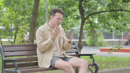 Fototapeta premium Angry Modern Young Man Doing Video Chat on Phone Outdoor