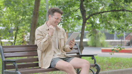 Fototapeta premium Modern Young Man Celebrating Success on Tablet Outdoor