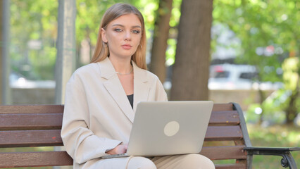 Young Businesswoman Looking at Camera while Working on Laptop Outdoor