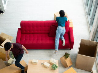 Asian young couple boy and girl busy unbox packaging when moving to new home and open all cardboard...