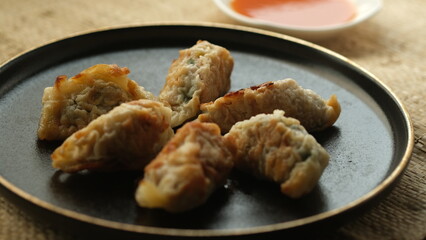 Japanese gyoza on a black plate.