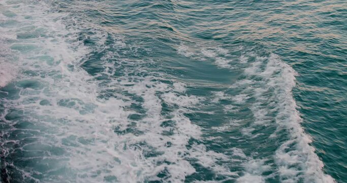 Top view of foamy waves from ship. Beautiful and frightening power of ocean with foaming waves from ship's motor at cloudy day. Set sail on ship to enjoy waves and feel boundless power of ocean.