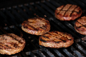 Barbecuing plant based Impossible Burger patties on electric grill semi close up shot panning over spatula flipped and grilled brown seasoned burger patties in Cinema. 4k 