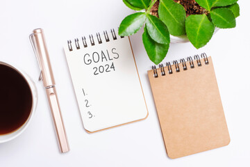 The inscription goals 2024 on notepad on white background, top view.