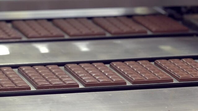 static slow motion medium shot of freshly made chocolate bars on the conveyor line