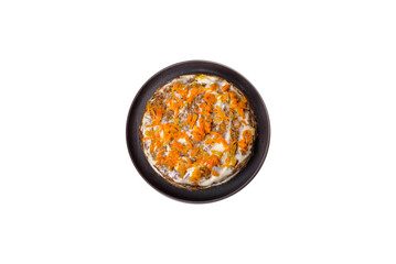 Delicious fresh liver cake with mayonnaise and carrots on a black plate against a dark concrete background