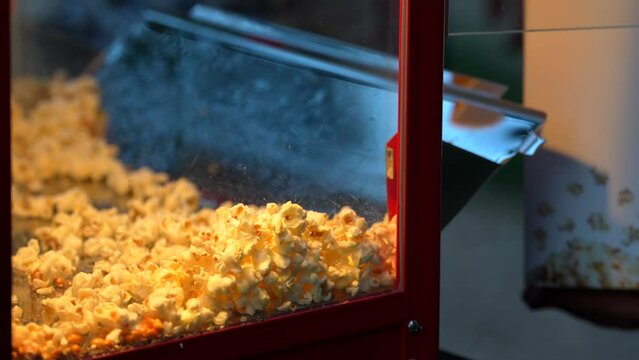 Popcorn served at an outdoor event. Close-up view of chef's hand serving freshly made popcorn 4k video.