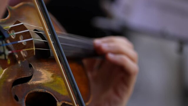 Violinist playing in a concert on a summer terrace. 4k video with the detail hand of a violonist singer artist