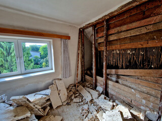 demolition of the attic of an old house. partitions made of boards and bricks were destroyed by a team with pneumatic hammers. it looks like it was hit by a missile or an earthquake.