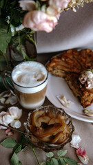 homemade apple pie with a cup of cappuccino and flowers
