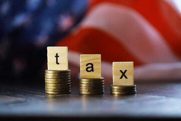 Tax Concept with wooden block on stacked coins