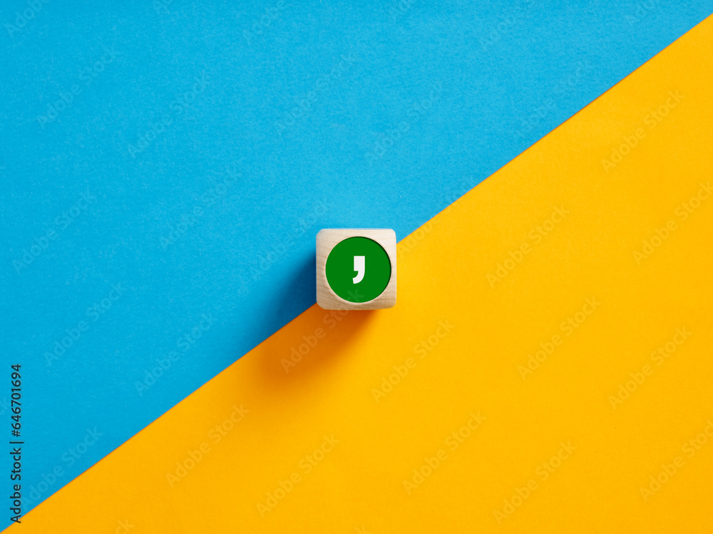 Poster the comma symbol on a wooden cube push button. separation concept.
