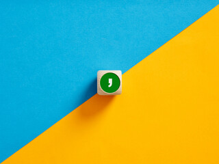 The comma symbol on a wooden cube push button. Separation concept.