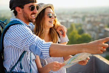 Happy couple on vacation sightseeing city with map. People travel fun love concept.