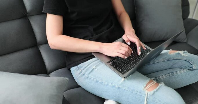 Female laptop user using computer, typing on keyboard. Homeowner in daily life freelance writer working sitting on home sofa