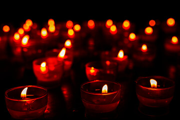 blurred background of red burning candles in lambadas in the dark. Day of Remembrance. Fire festival in India