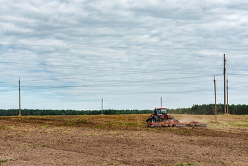 A tractor prepares the land using a seeder cultivator in autumn time.