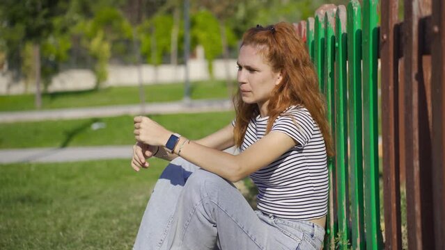 Young woman sitting on the ground in panic.