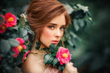 Naklejka premium Portrait of a beautiful red hair girl in a pink vintage dress standing near colorful flowers. Art work of romantic woman .Pretty tenderness model .