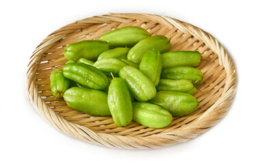 green bilimbi kamias fruit in bamboo plate isolated on white background. pile of green bilimbi kamias fruit isolated. heap of green bilimbi kamias fruit isolated                               