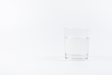 A glass of water on the table. On a white background.