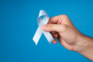 Blue ribbon in a man's hand, Movember concept