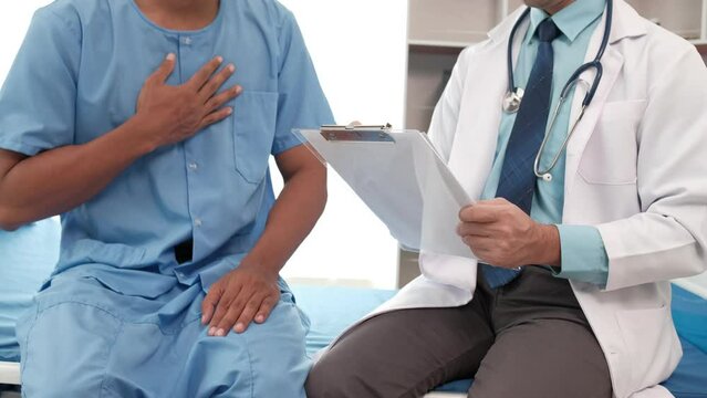 Doctor with clipboard and young man patient meeting at hospital, healthcare and people concept