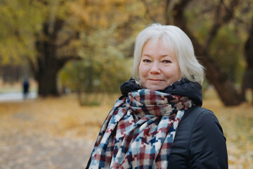 portrait of happy smiling senior womanin autumn park