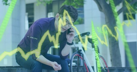 Animation of stock market data processing against asian man talking on smartphone on the street - Powered by Adobe