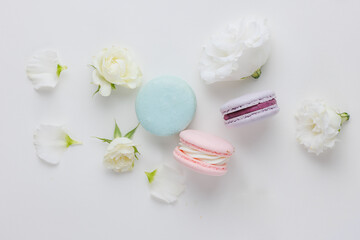 Fototapeta na wymiar Top view Set Beautiful colorful French macaroons and flowers. Spring Flat lay white background