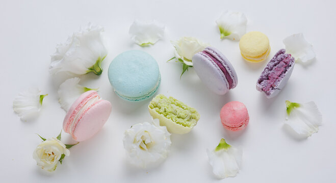 Beautiful Set colorful French macaroons and flowers. Flat lay, top view, spring white background. Concept banner Valentines, Birthday, Woman or Mothers Day gift