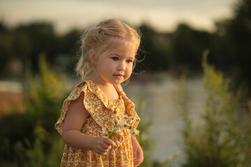 heartfelt smile of girl holding daisies, set against simple park background, advocates for a return...