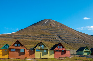 Fototapeta na wymiar Colorful old coal mining houses on the hills of Longyearbyen, the world's northernmost settlement, Spitsbergen, Svalbard, Norway