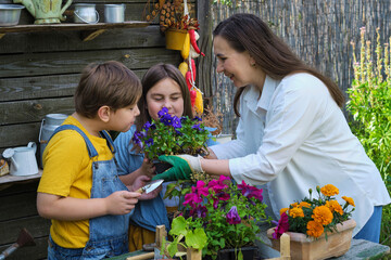 A family engrossed in garden work, as a smiling mother educates her kids about sustainable living and organic gardening.