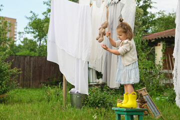 Whimsical Laundry. The birds and trees witness a playful child antics, as she gleefully tries to...
