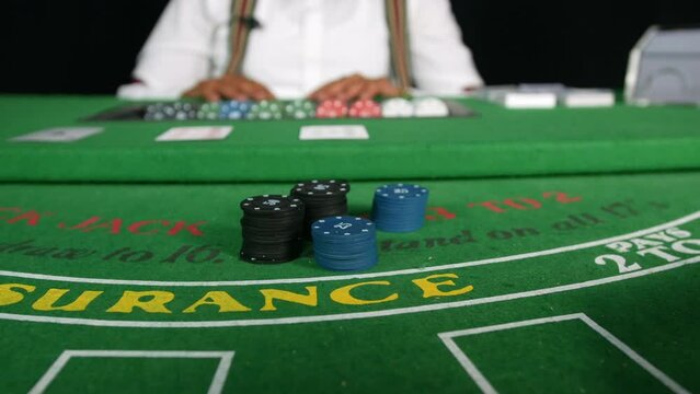 Poker players placing bets with poker chips on a black jack tabble in a casino close up