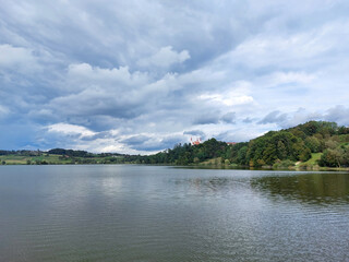Fototapeta na wymiar lake near Church of the Holy Trinity in Slovenske Gorice under cloudy sky. Slovenia