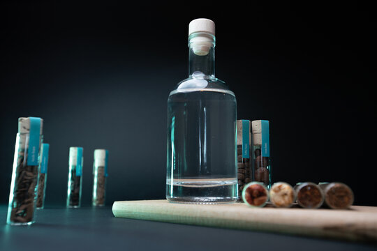 Spices and clear liquid, in blue lighting on black background. Moonshine liquor photo shoot.