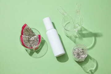 Few beakers containing test tubes and dragon fruit slices displayed with unlabeled bottle. Dragon fruit (Hylocereus) helps reduce acne thanks to the presence of vitamin C content