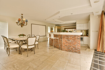 a kitchen and dining area in a house with white walls, tile flooring and an orange brick accent wall