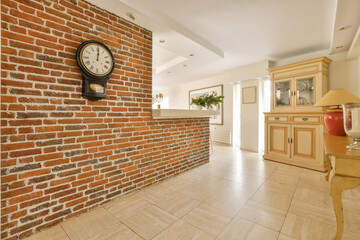 a brick wall with a clock hanging on it's side in a living room next to a dining area