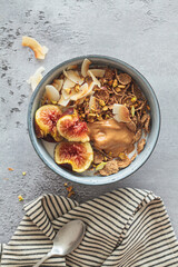 Multigrain breakfast cereals with fig, coconut chips, peanut butter and pistachio. Vegan breakfast concept.