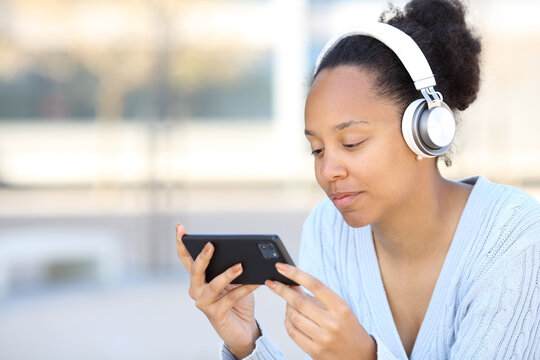 Black Woman Wearing Headphone Watching Video