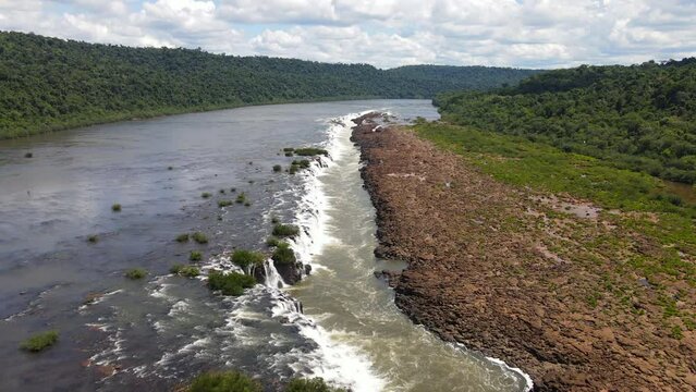 Aerial zoom in of the Saltos del Mocon&aacute; or Salto do Yucum&atilde; captured on an incredibly clear and blue day, showcasing the majestic beauty of the longitudinal waterfalls on the Argentina-Brazil border