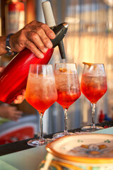 Spritz traditional cocktail with alcohol being prepared in a beach bar. Italian drink. Lifestyle...