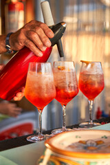 Spritz traditional cocktail with alcohol being prepared in a beach bar. Italian drink. Lifestyle concept