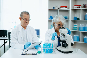 Asian senior Scientist team meeting and writing analysis results in the laboratory study and analyze scientific sample.