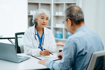Fototapeta premium Asian Senior Doctor and patient discussing something while sitting at the table . Medicine and health care concept.
