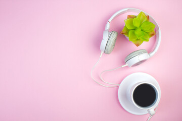 Headphones, mobile phone, idiobook, coffee cup on a pink background. The concept of leisure and learning, hobby. Listen to music, literature. Top view with copy space.